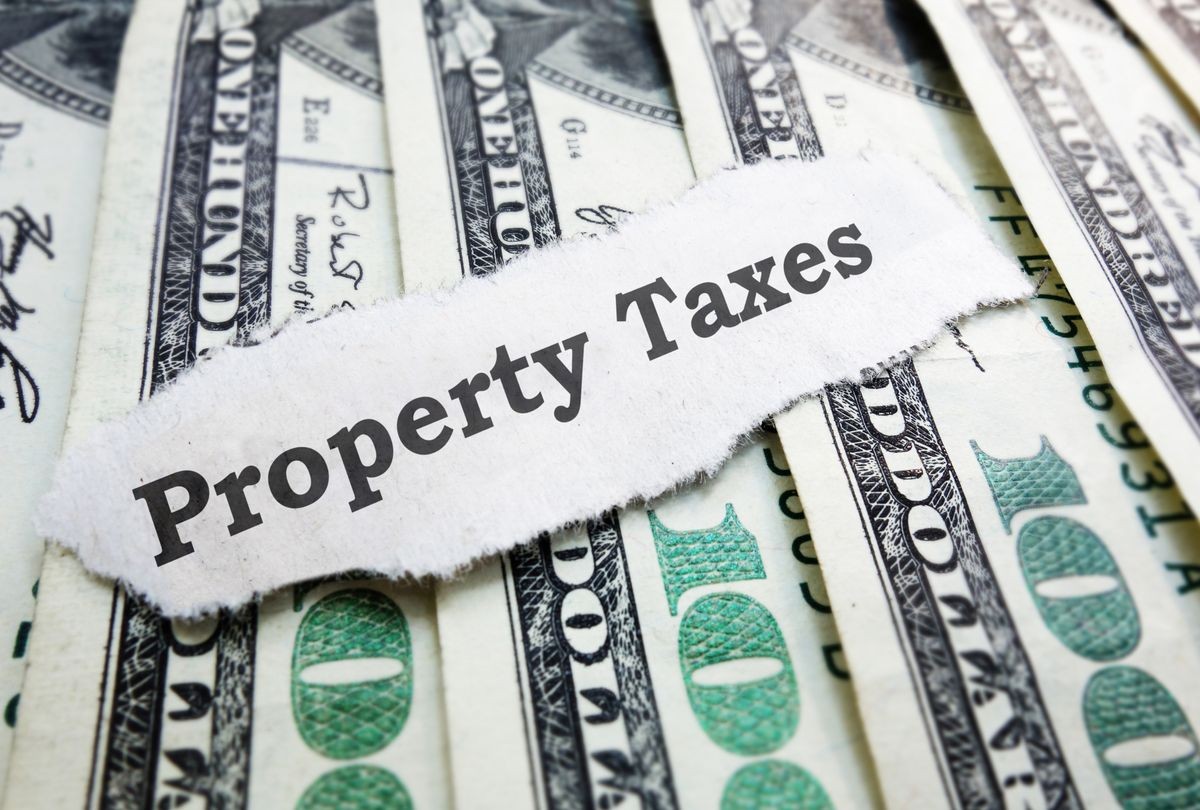Property Taxes paper message on assorted money                               